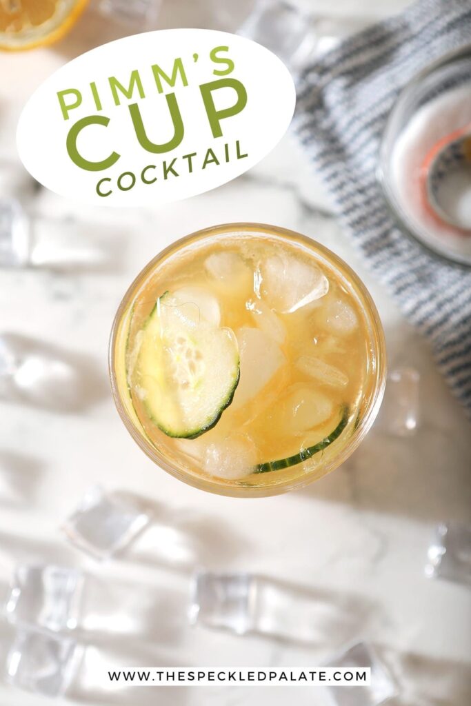 A Pimm's Cup from above, surrounded by ice and ingredients, is served on a marble surface, with Pinterest text