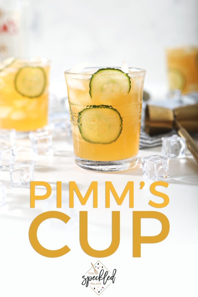 A Pimm's Cup, surrounded by ice and ingredients, is served on a marble surface, with Pinterest text