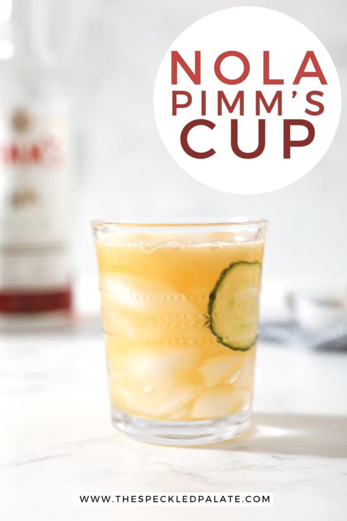 A Pimm's Cup, surrounded by ice and ingredients, is served on a marble surface, with Pinterest text