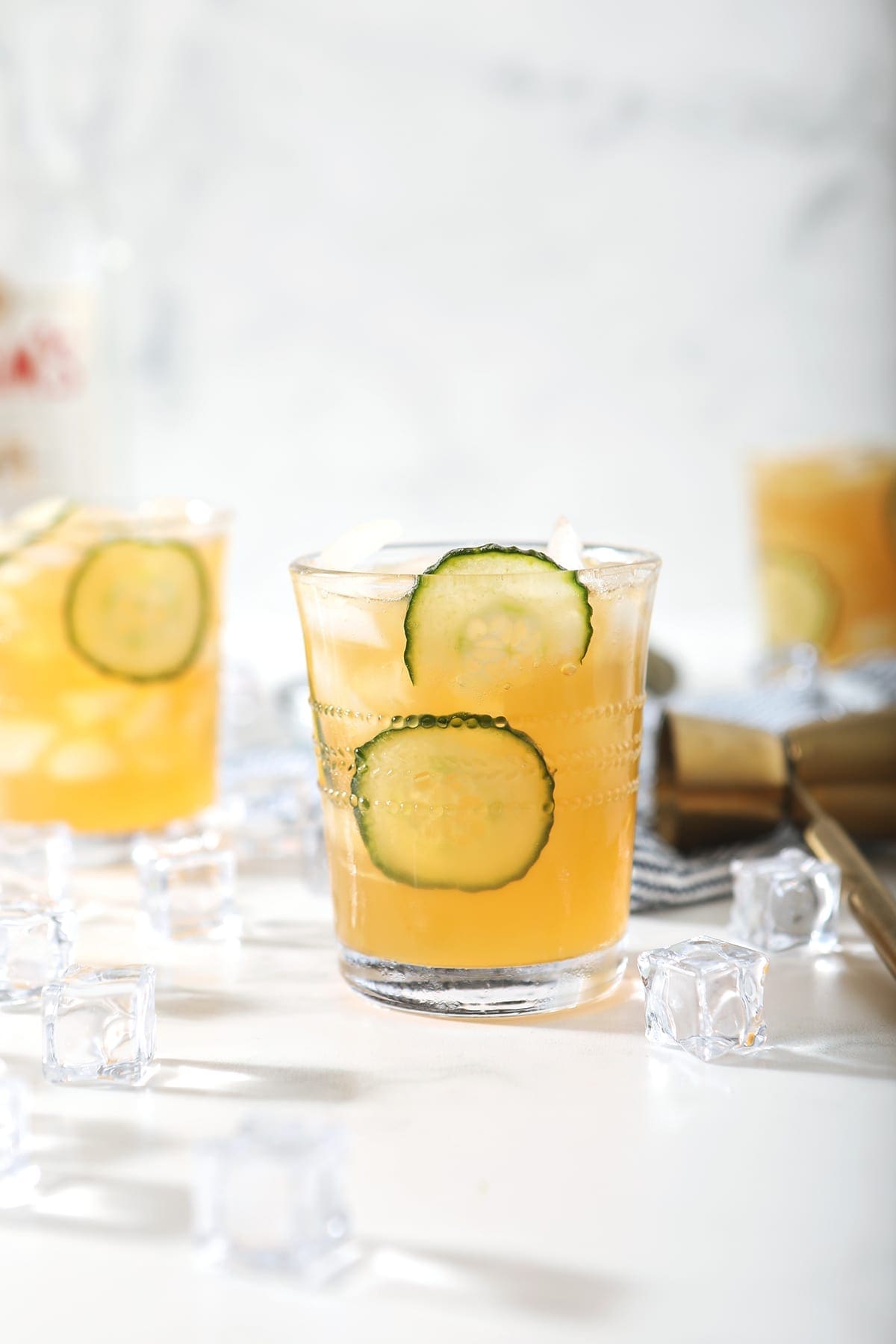 A Pimm's Cup, surrounded by ice and ingredients, is served on a marble surface