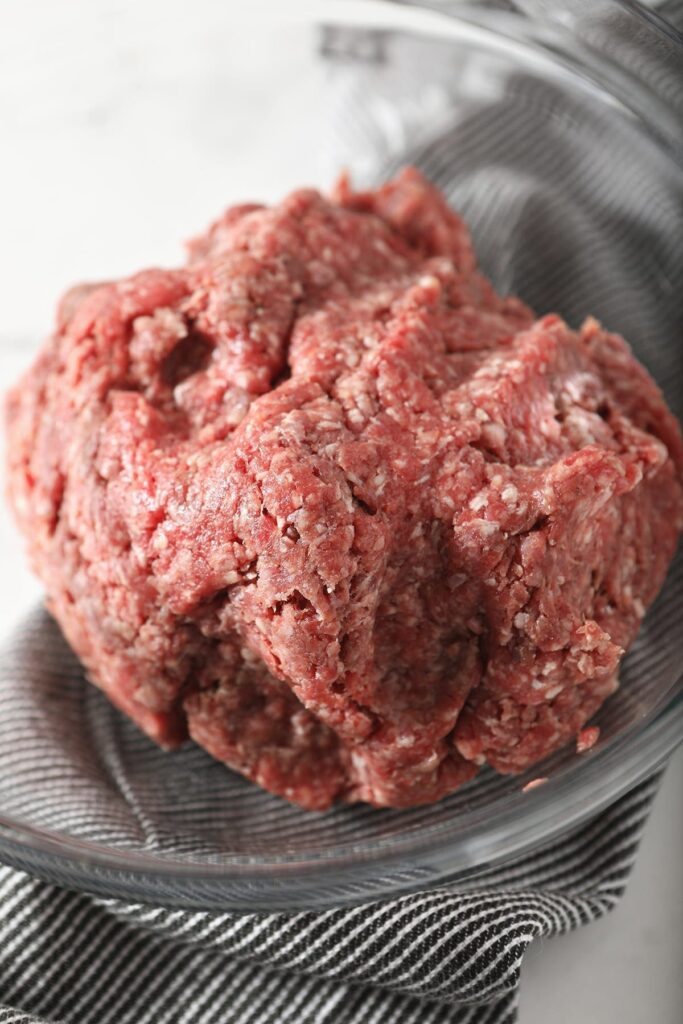 Close up of ground beef with seasonings after mixing in a bowl