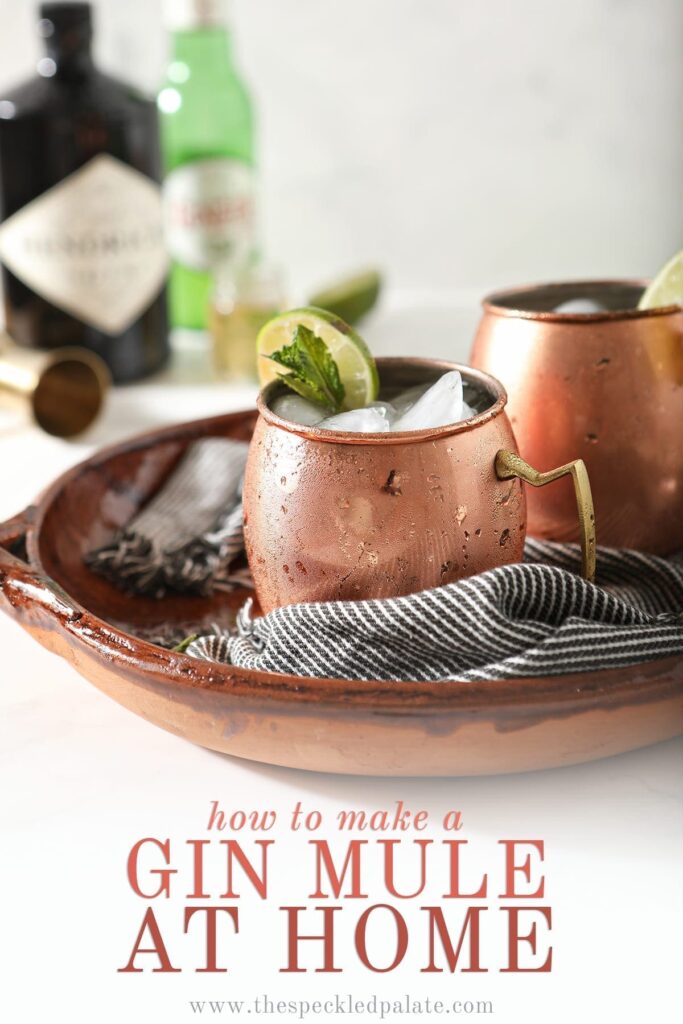 Two copper mugs garnished with lime rounds and mint are shown in a brown serving tray holding Gin Gin Mules, with text stating "How to Make a Gin Mule at Home"