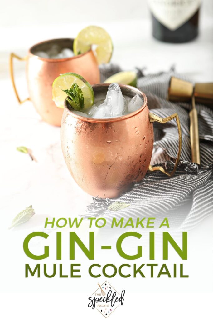 Two Gin Gin Mules in copper mugs on a marble surface sit next to a blue striped towel, lime rounds and mint leaves, with text stating "How to Make a Gin-Gin Moscow Mule"