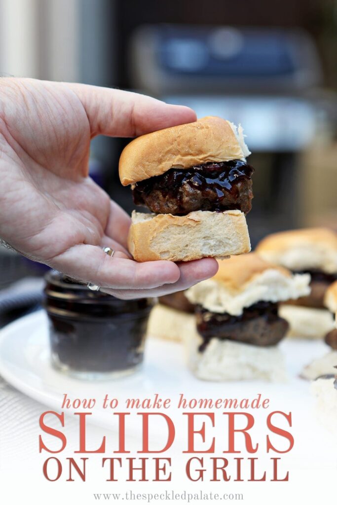 A man holds a slider with compote on it in front of agrill with the words "how to make homemade sliders on the grill"