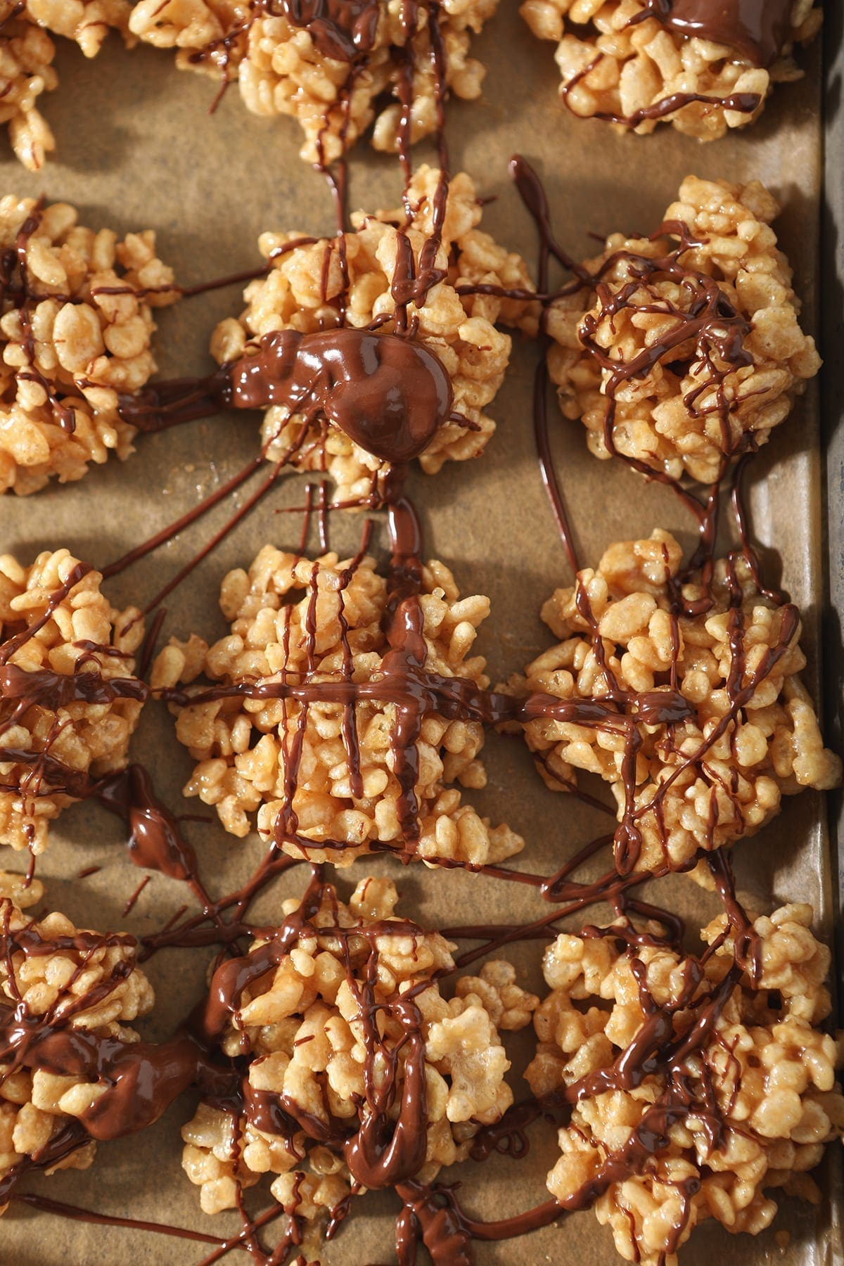 Close up of No Bake Peanut Butter Cookies drizzled with chocolate and butterscotch on a baking sheet