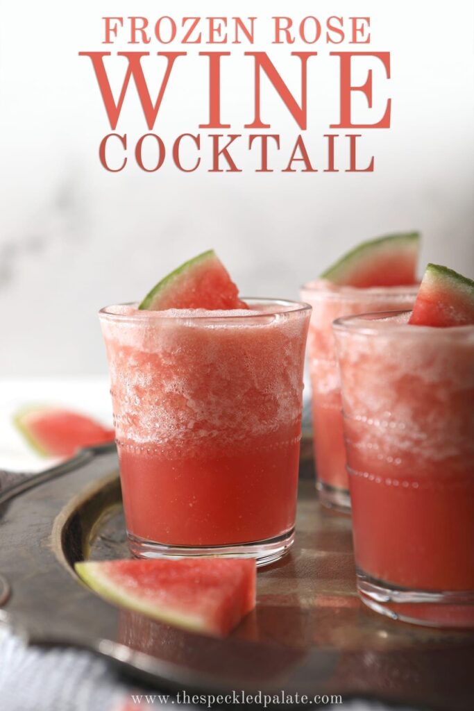 Three glasses holding pink slushy Watermelon Froses garnished with watermelon wedges on a silver platter, with text saying "Frozen Rose Wine Cocktail"