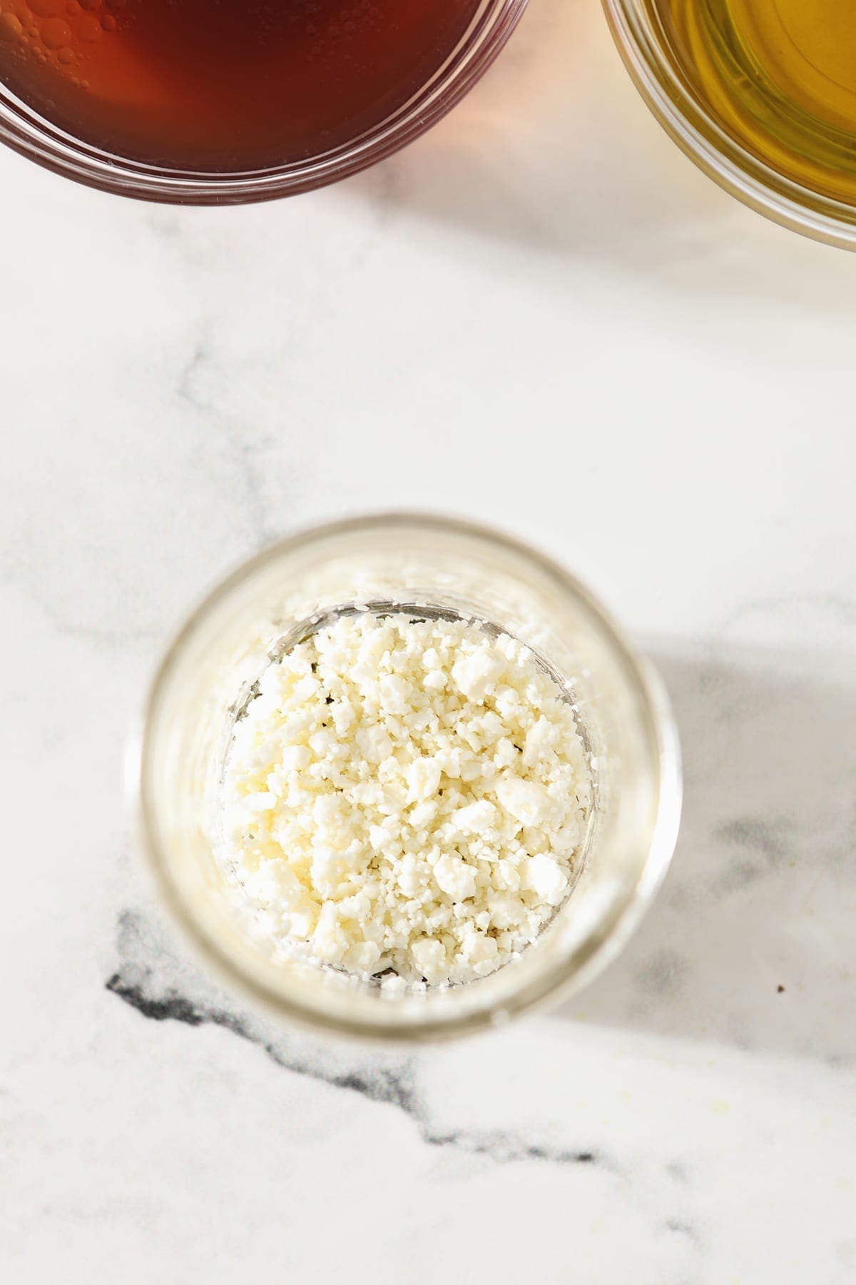 Feta cheese in a mason jar on a marble surface