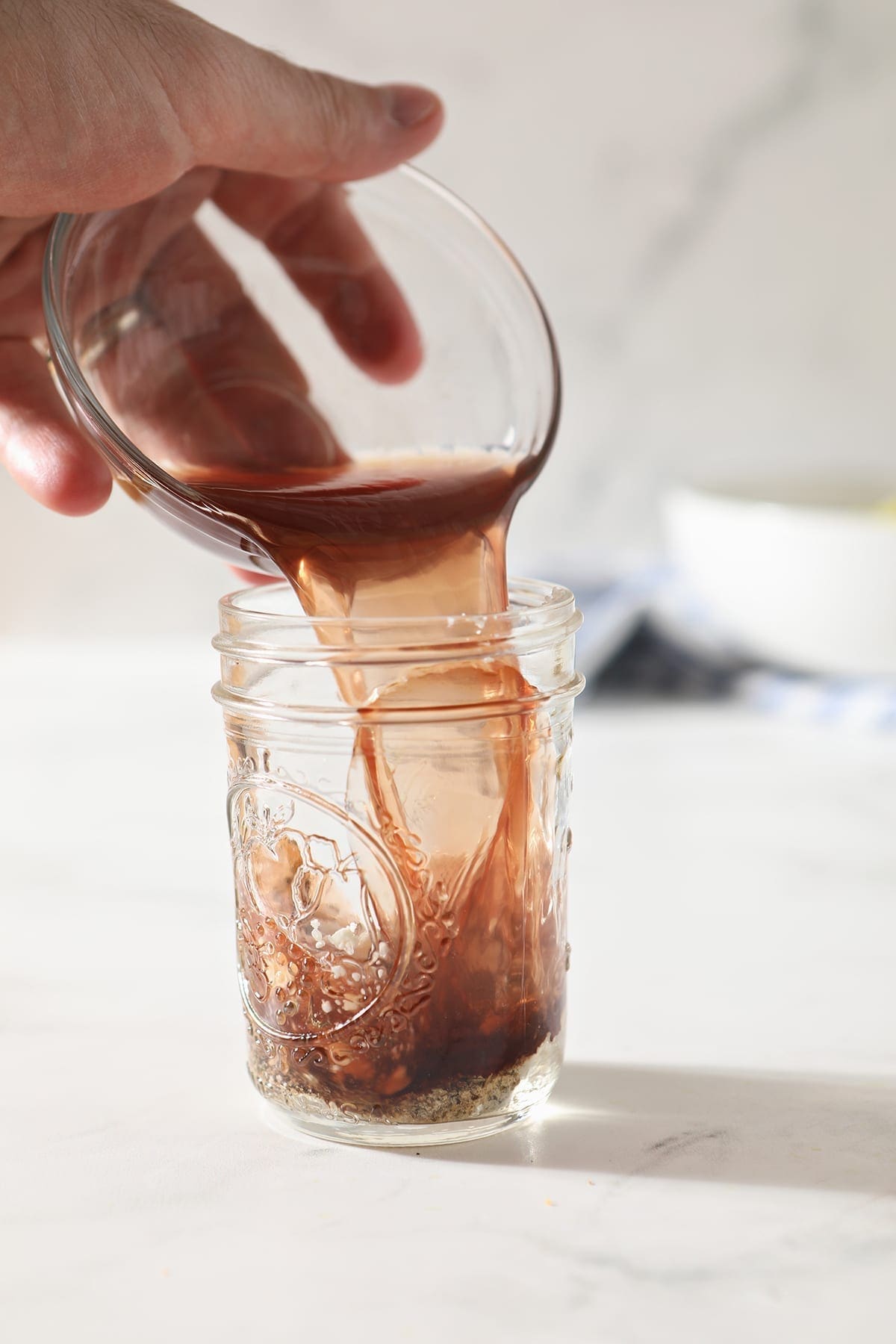 Red wine vinegar pours into a small mason jar