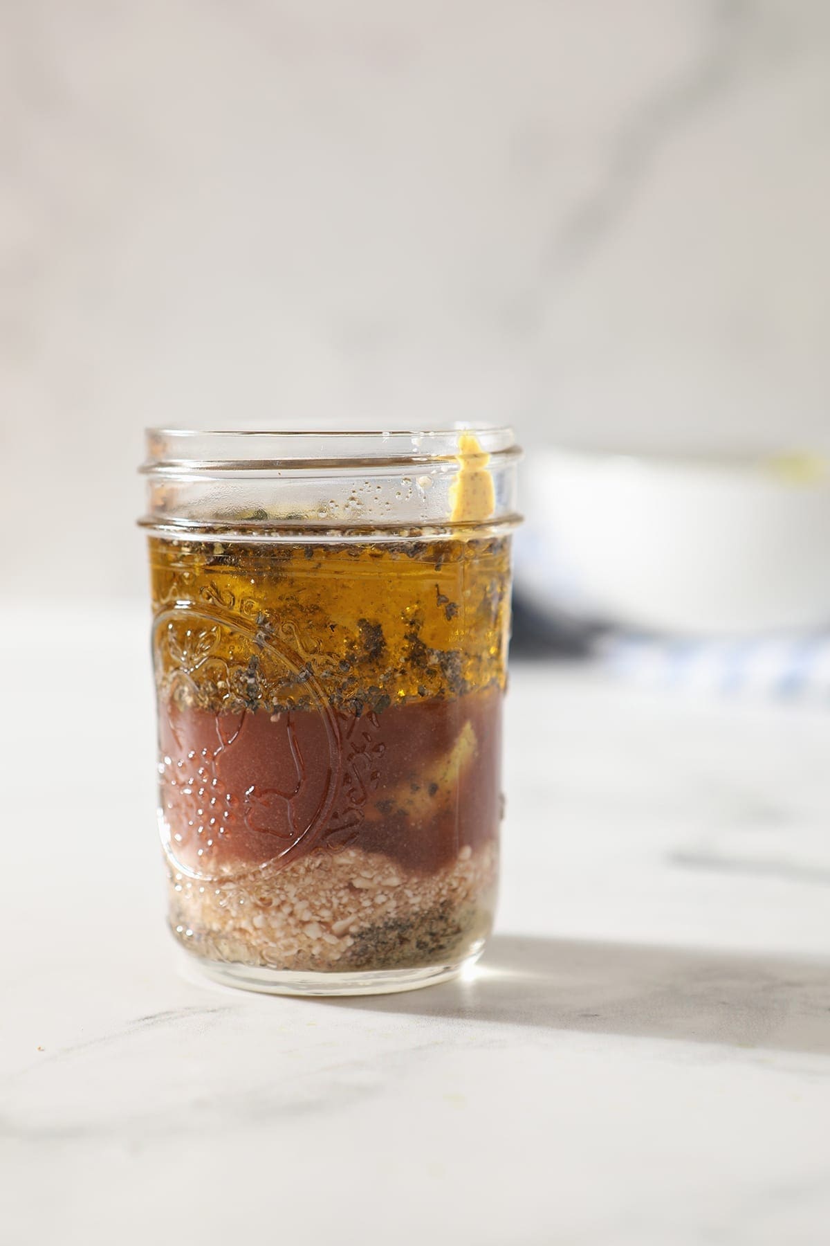 Feta ingredients in a mason jar on a marble surface, before shaking