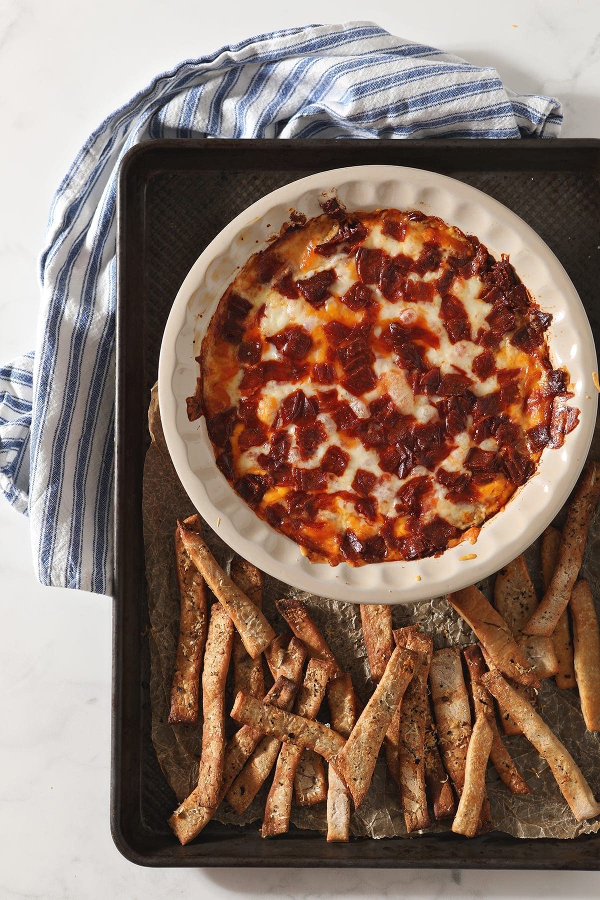 Pepperoni Dip, from above, after baking, on a sheet pan with homemade pizza breadsticks