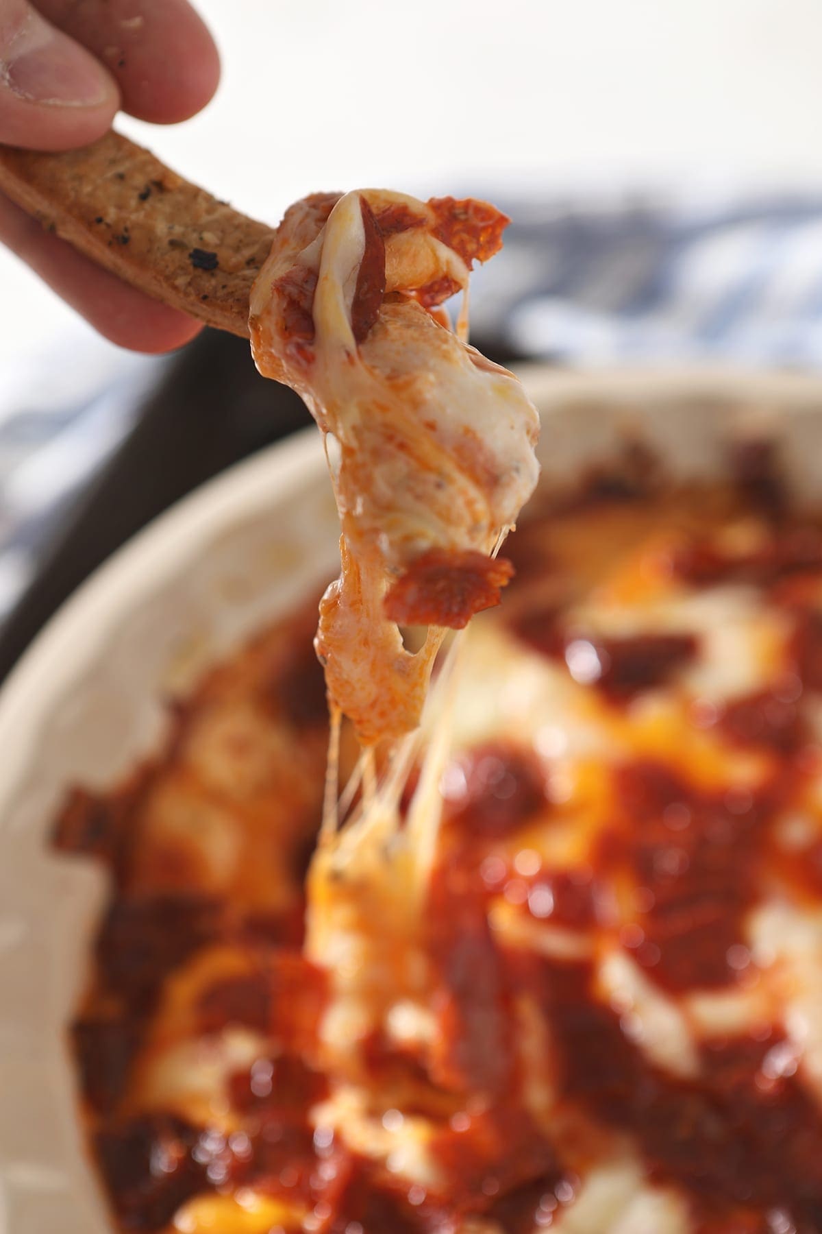 Pepperoni Dip clings to a homemade breadstick, just before eating