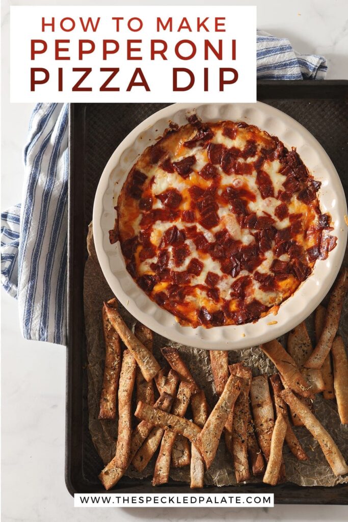 Pepperoni Dip, from above, after baking, on a sheet pan with homemade pizza breadsticks with the text 'how to make pepperoni pizza dip'