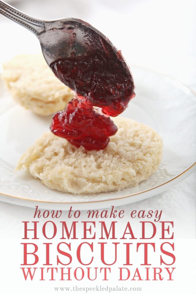 A spoon dollops raspberry jam into the middle of a vegan biscuit with the text 'how to make easy homemade biscuits without dairy'