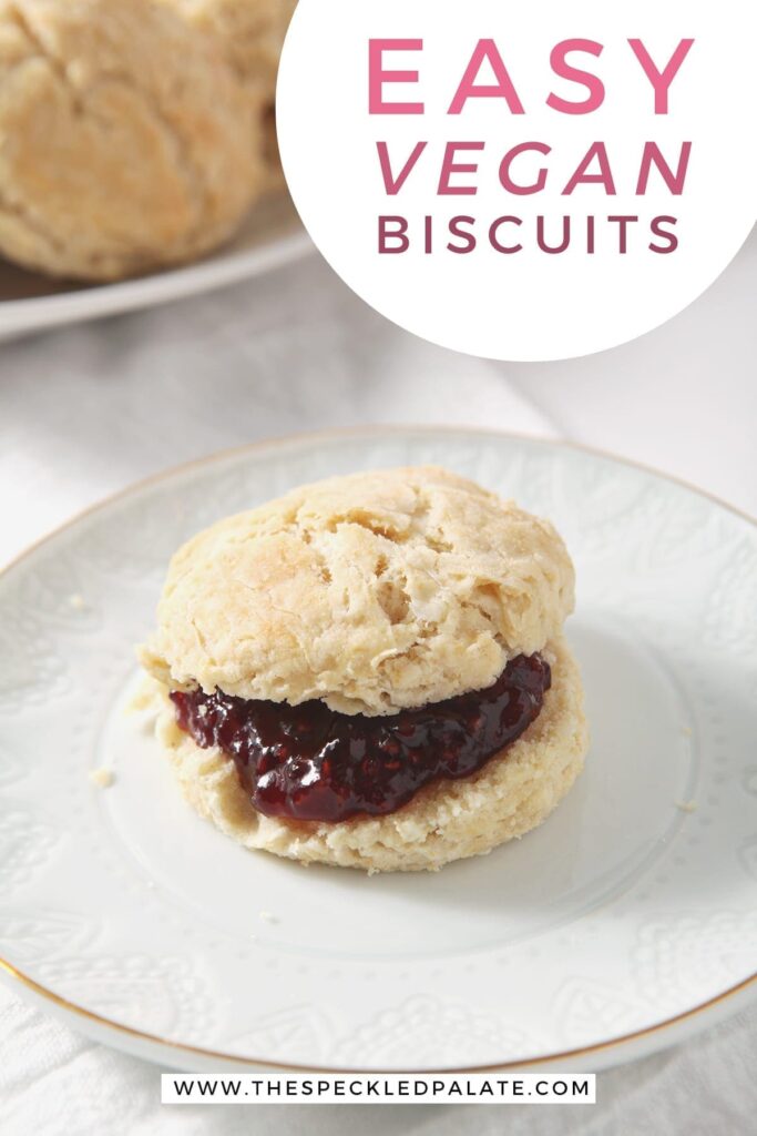 A biscuit with raspberry jam on a white plate with other biscuits in the background with the text 'easy vegan biscuits'