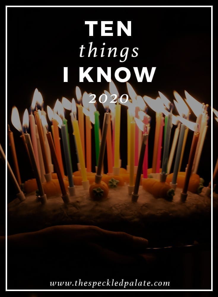 A birthday cake with lit candles on a dark background with the text overlay '10 things i know 2020'