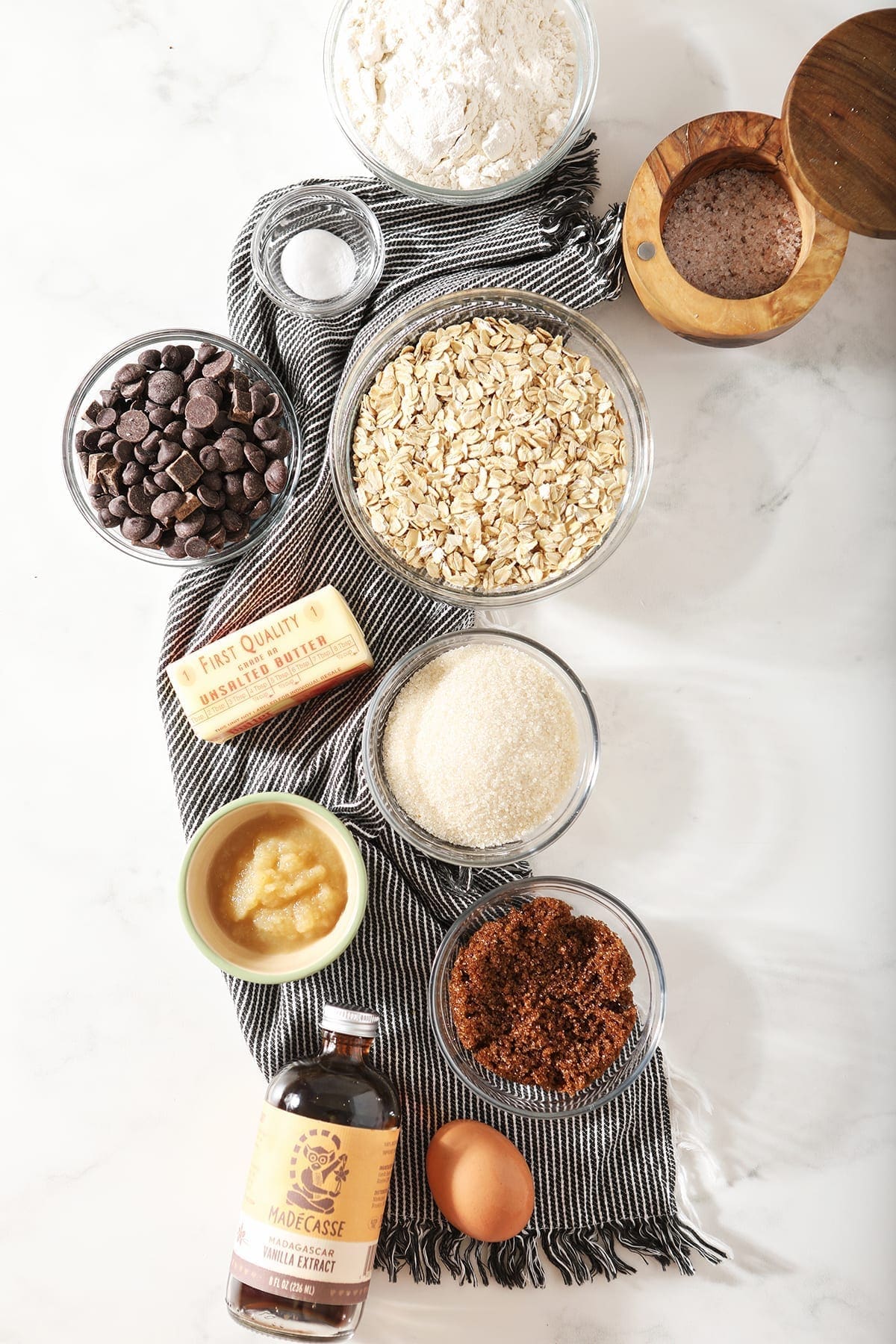 Cookie ingredients in bowls on a dark grey towel, before mixing