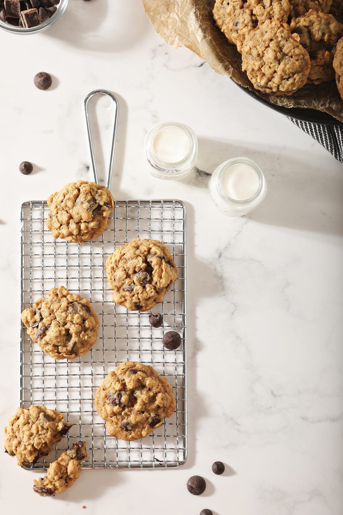 Several cookies on a wire cooling rack with milk around them