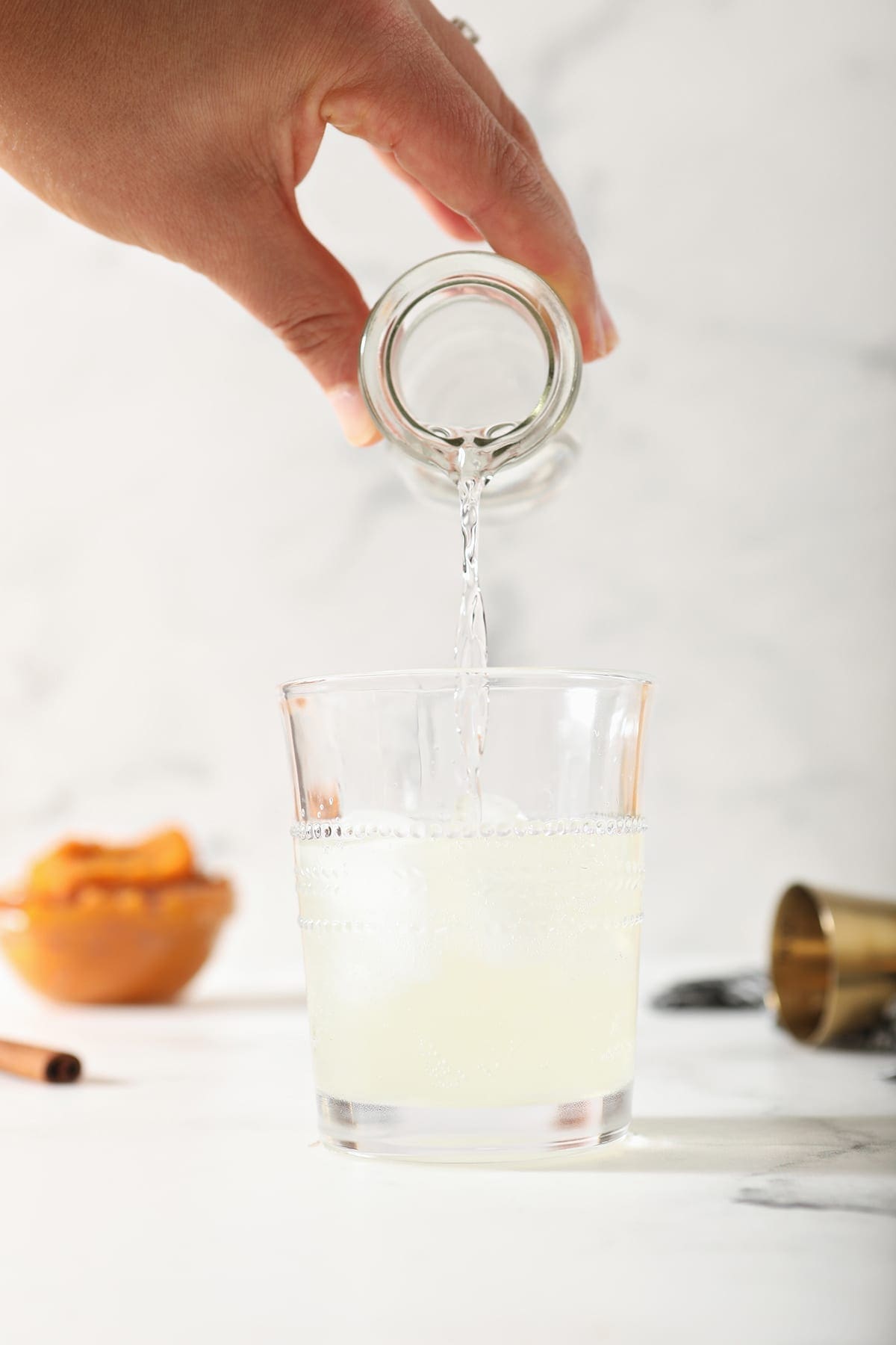 Vodka is poured into a glass of ginger beer