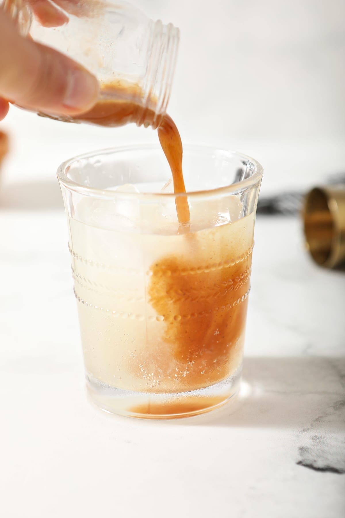 A shot of pumpkin spice syrup is poured into the drink