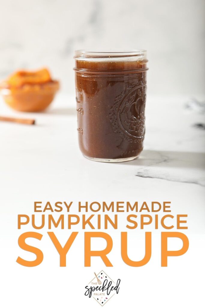 A jar of Pumpkin Spice Syrup sits on marble with a cinnamon stick and pumpkin puree behind it with the text 'easy homemade pumpkin spice syrup'