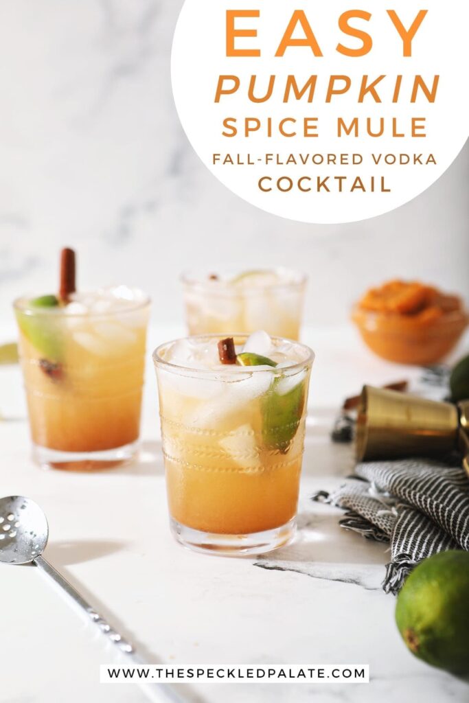 Three Pumpkin Mules on marble next to limes, a cocktail spoon and a bowl of pumpkin puree with the text 'easy pumpkin spice mule. fall-flavored vodka cocktail'