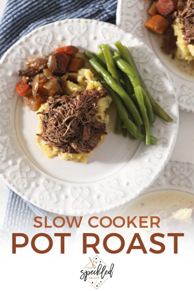 Two plates hold shredded slow cooker pot roast with mashed potatoes, steamed green beans and slow cooked veggies from above with the text 'slow cooker pot roast'