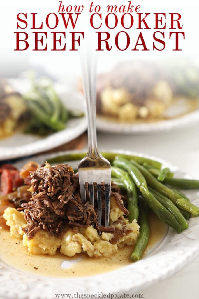 Close up of a fork sticking shredded slow cooker pot roast on top of mashed potatoes and next to steamed green beans with the text 'how to make slow cooker beef roast'