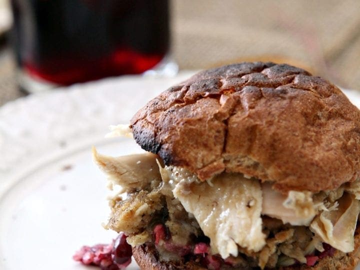 A Turkey Cranberry Sandwich on a toasted bun sits on a white plate