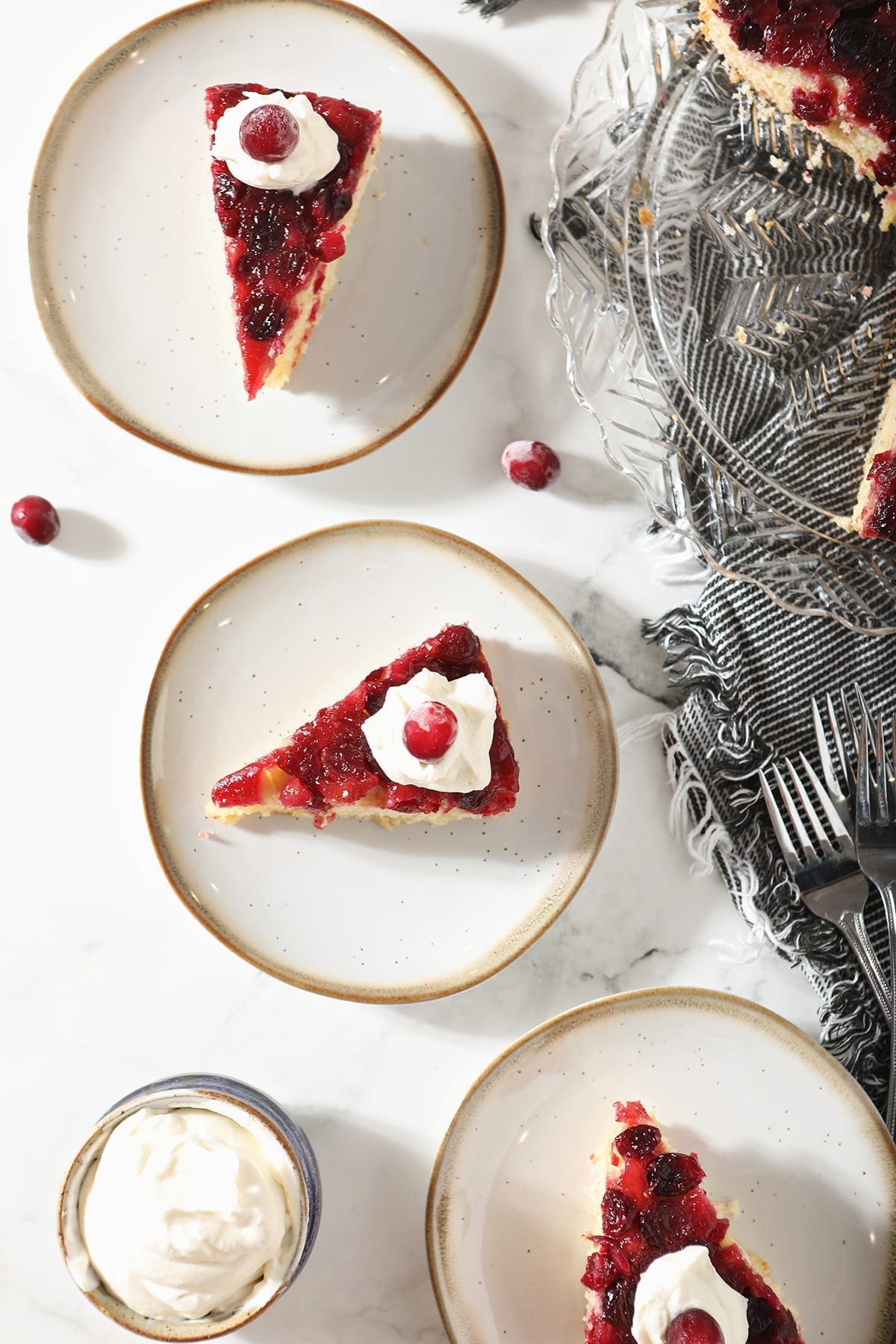 Overhead of three plates holding slices of Cranberry Cake