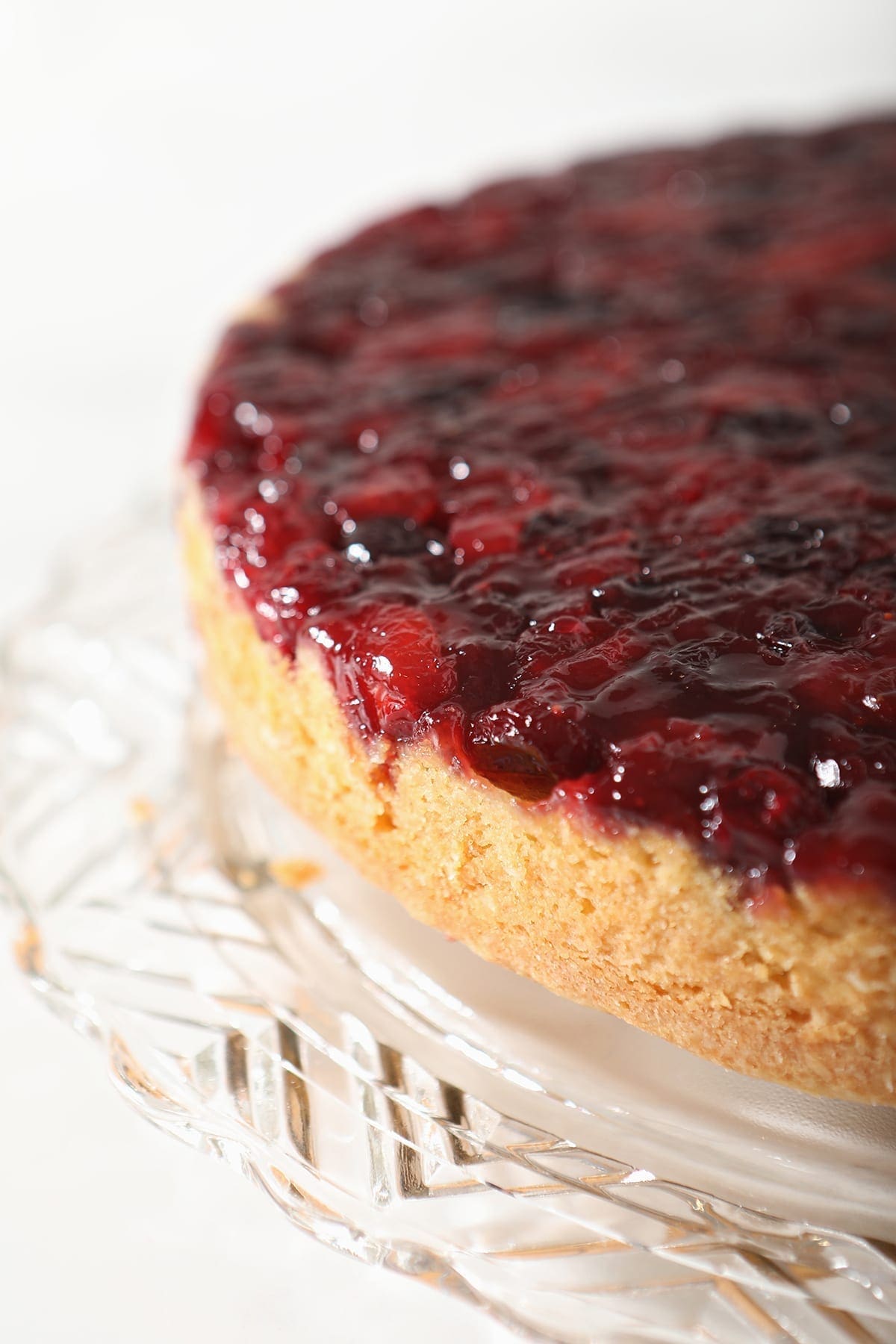 Close up of the Upside Down Cranberry Cake on a decorative glass cake plate