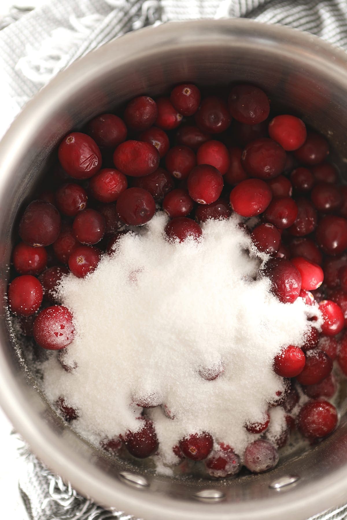 Cranberries with sugar in a saucepan from above