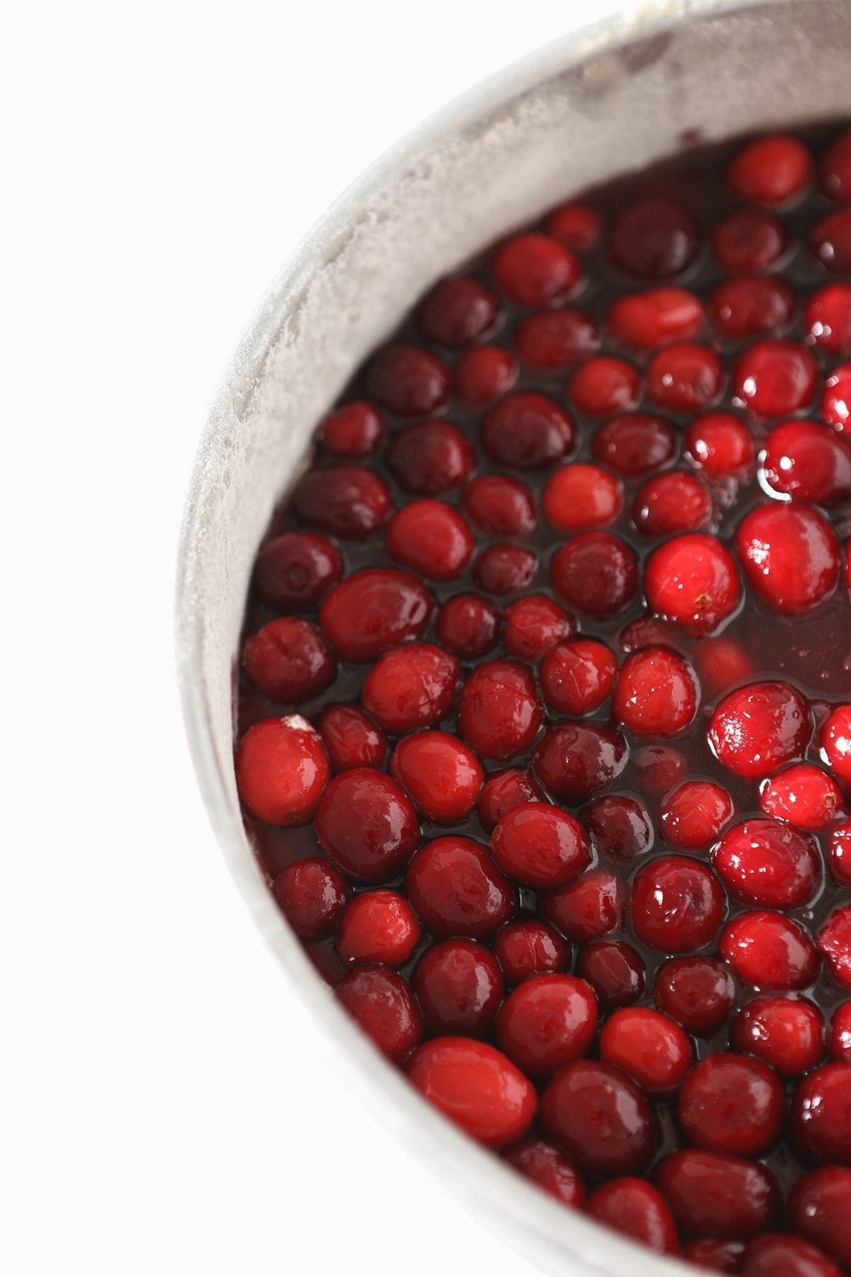 Cranberries and their juices in a round silver cake pan