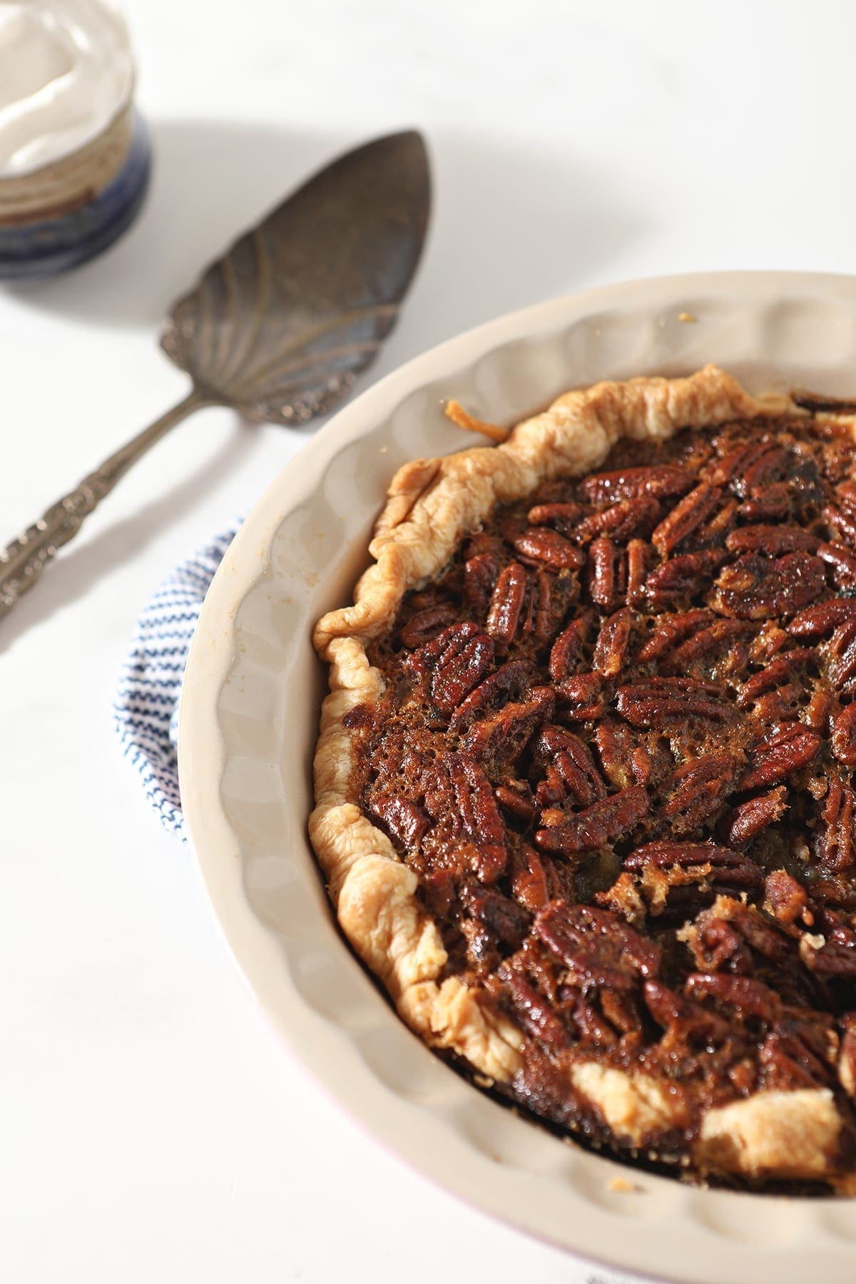 A Bourbon Pecan Pie after baking next to a serving utensil