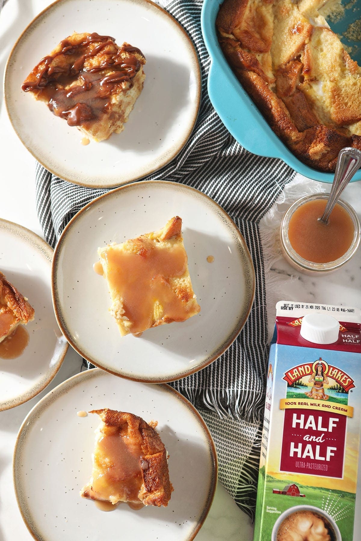 bread pudding on white plates and caramel sauce in a jar