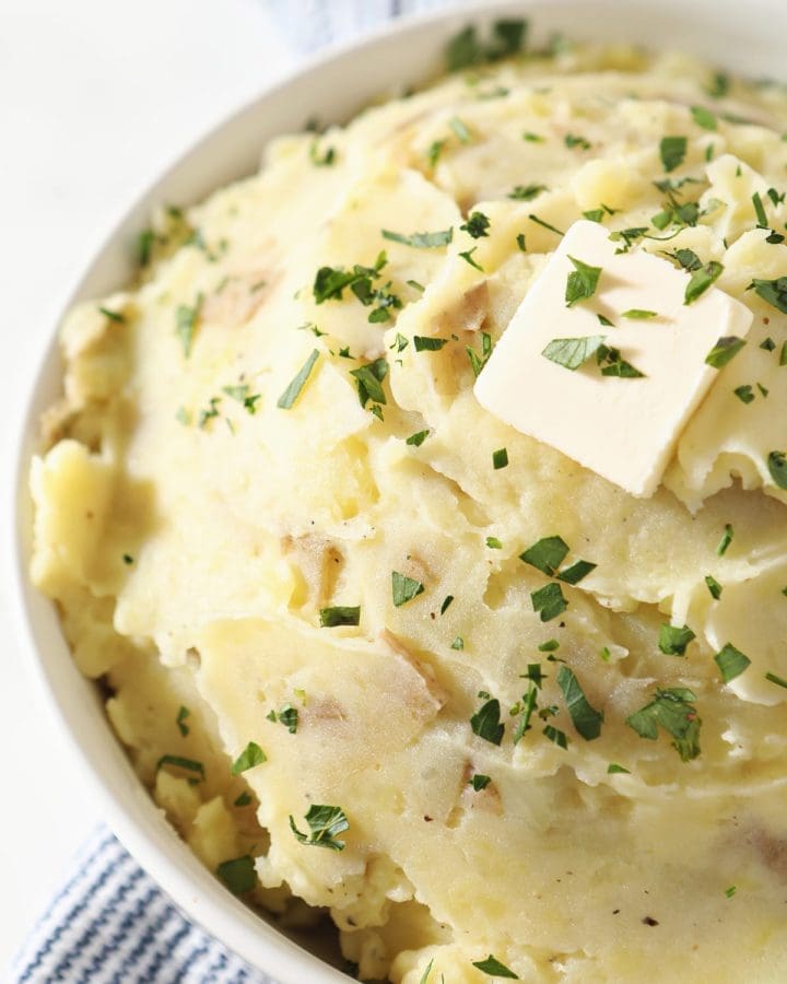 Close up of a white bowl holding creamy mashed potatoes