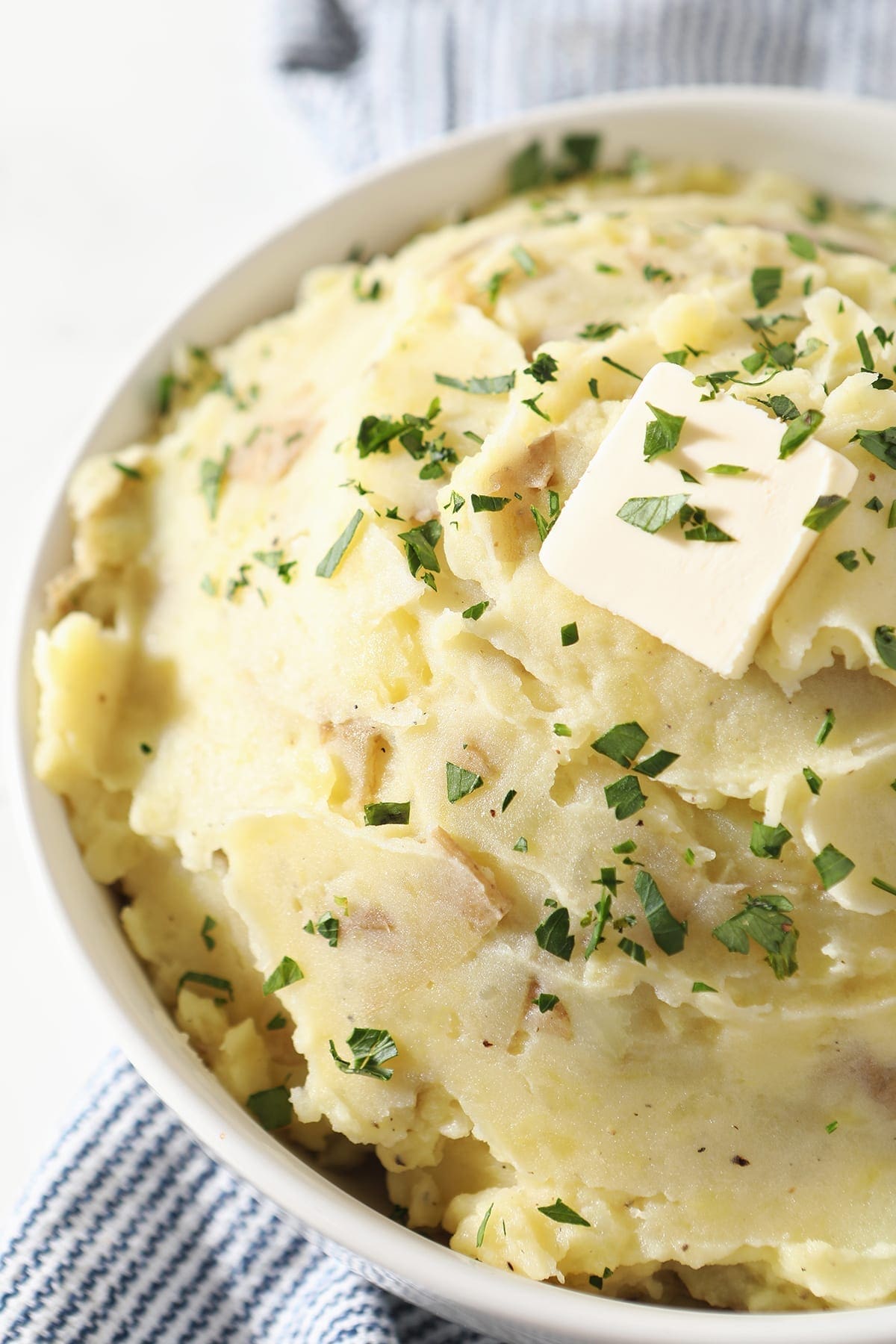 Close up of a white bowl holding creamy mashed potatoes