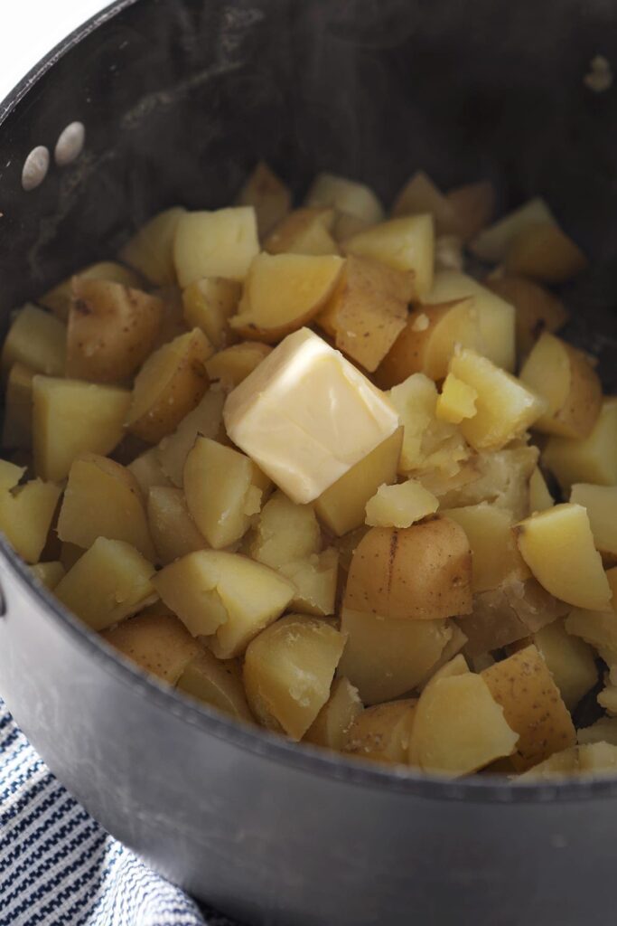 Butter sits on top of boiled potatoes