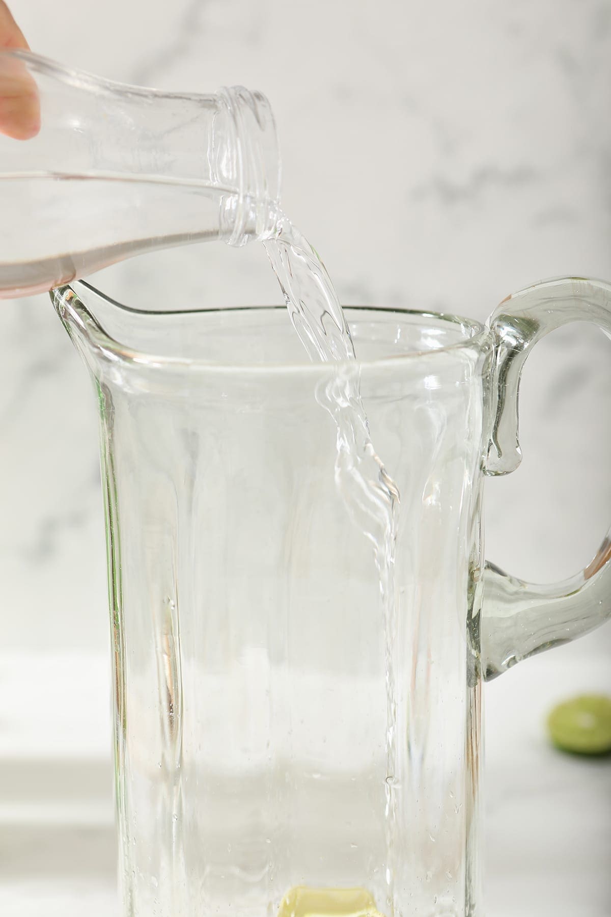 Vodka pours into a tall pitcher