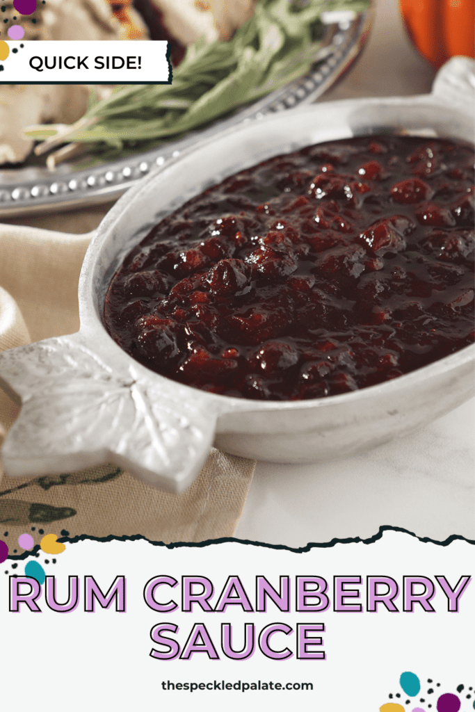 Cranberry sauce in a silver bowl with leafs on the ends next to a silver platter of turkey with the text 'rum cranberry sauce'