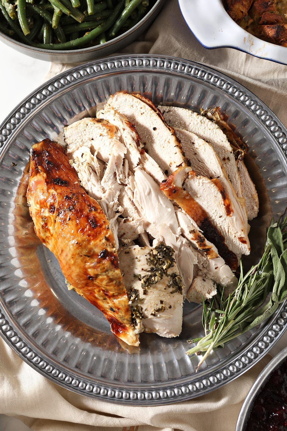 Close up of roasted turkey breast with herb butter on a silver platter