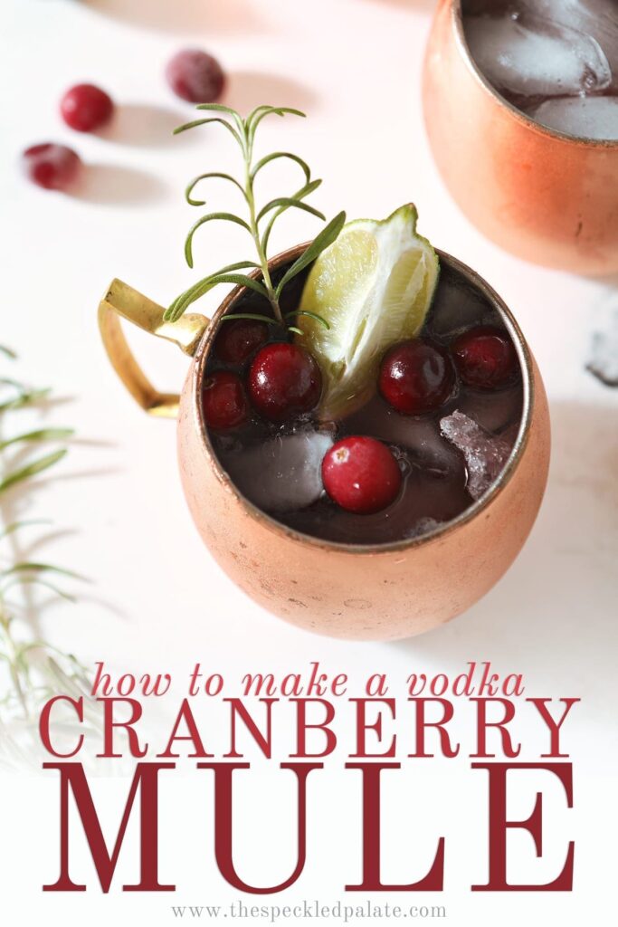 A Cranberry Moscow Mule from above garnished with a lime, cranberries and a rosemary sprig next to two other copper mule mugs with the text 'how to make a vodka cranberry mule'