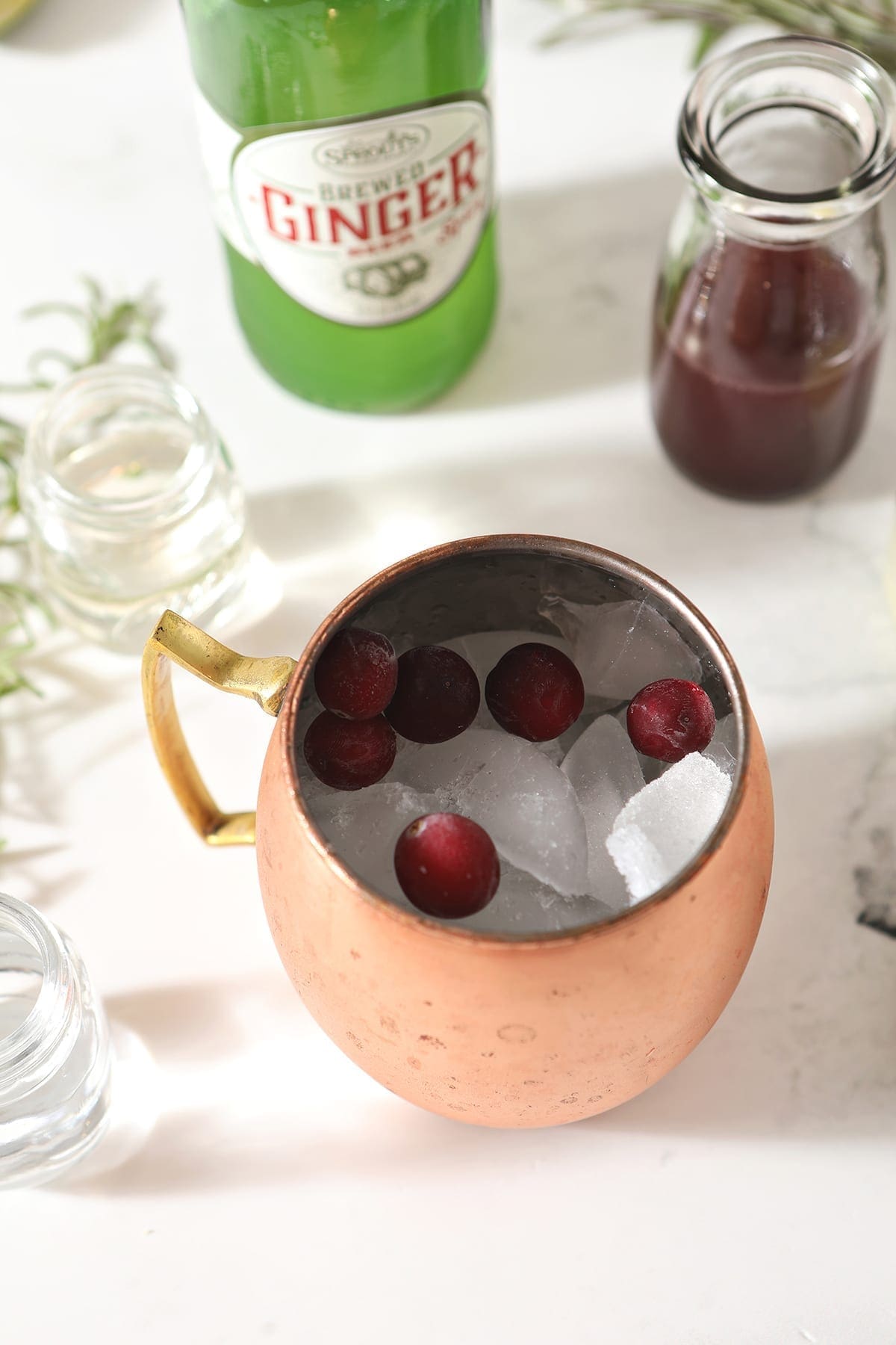 Cranberries and ice sit inside a copper mug