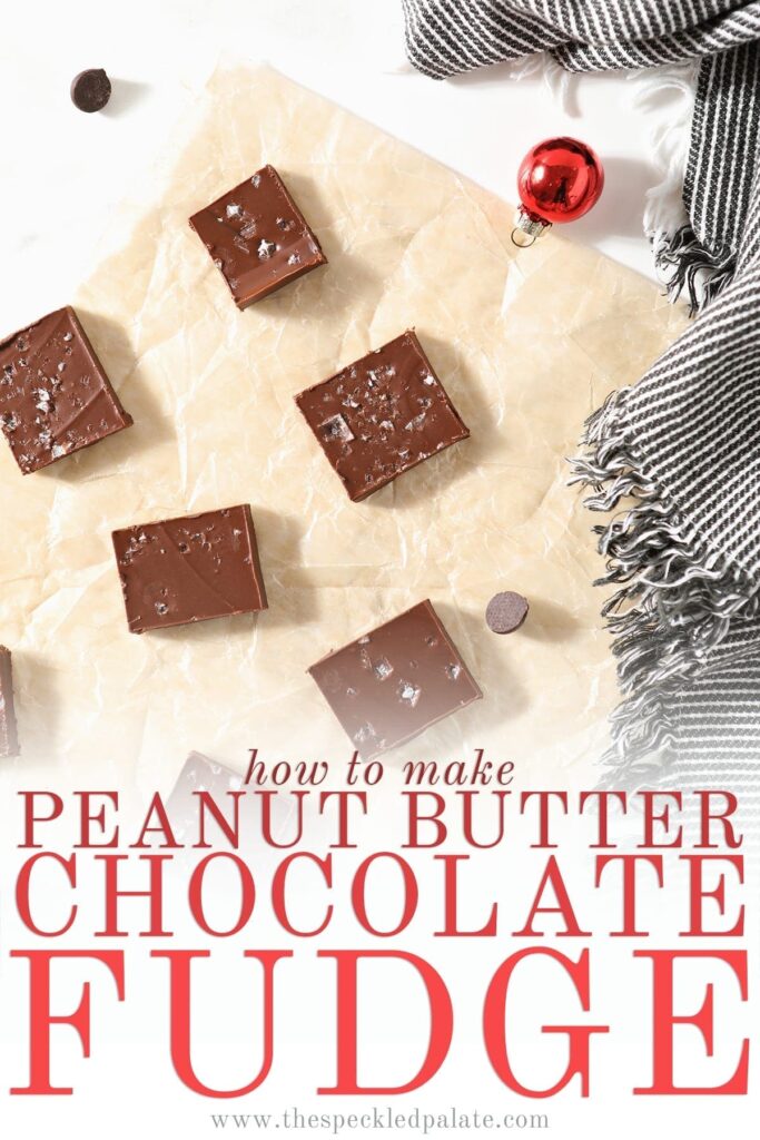 Slices of Peanut Butter Chocolate Fudge on a piece of parchment, surrounded by chocolate chips, festive small ornaments and a gray and white striped towel with the text 'how to make peanut butter chocolate fudge'