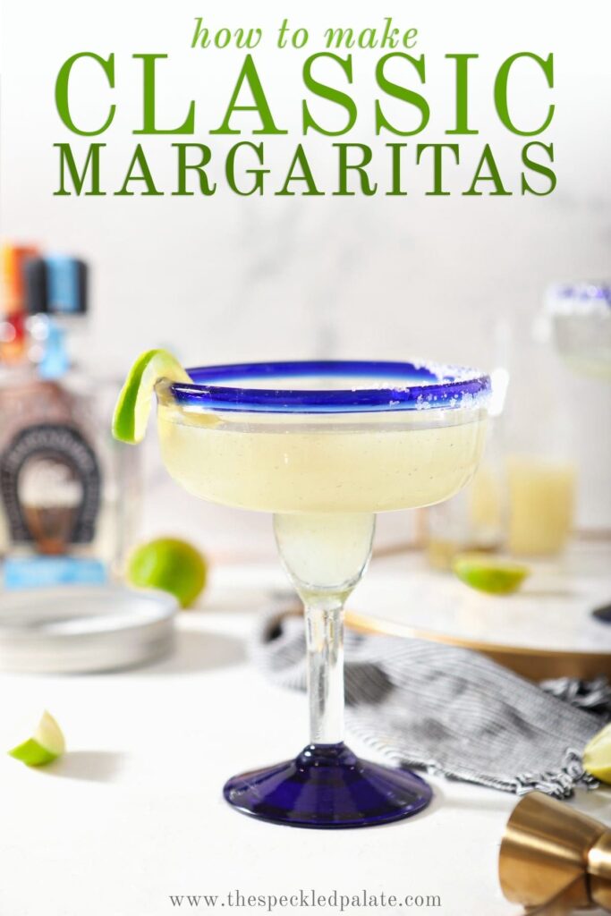 A margarita sits on a marble counter in front of ingredients with the text 'how to make classic margaritas'