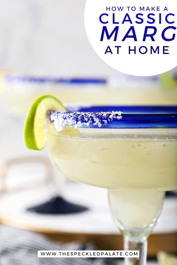 Close up of a lime twist on the salted rim of a margarita with the text 'how to make a classic marg at home'