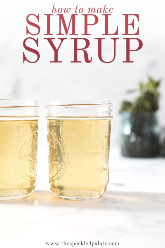 Two jars holding simple syrup sit on a marble surface in front of a jar holding fresh mint leaves with the text 'how to make simple syrup'