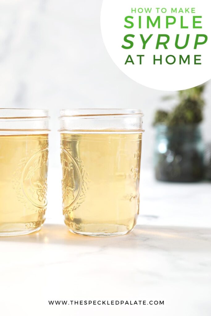 Two jars holding simple syrup sit on a marble surface in front of a jar holding fresh mint leaves with the text 'how to make simple syrup at home'