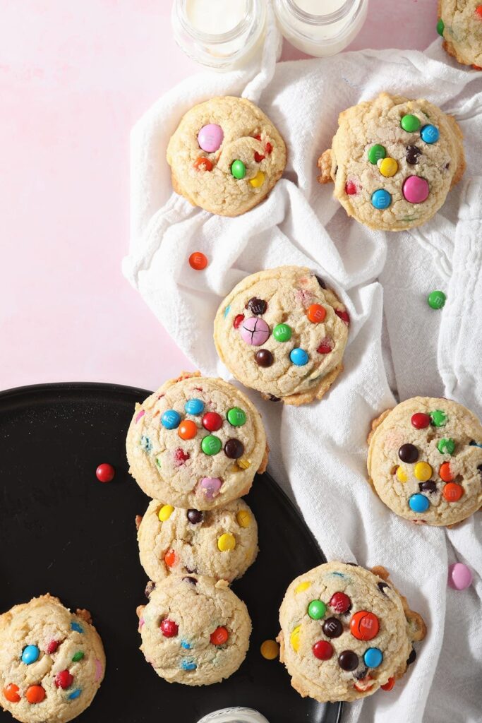 M&M Cookies sit on a black plate and a white towel