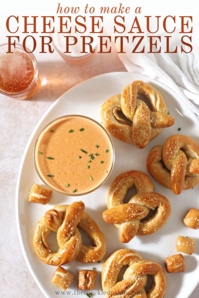 Soft baked pretzels sit around a bowl of cheese dip on a white platter with the text 'how to make a cheese sauce for pretzels'