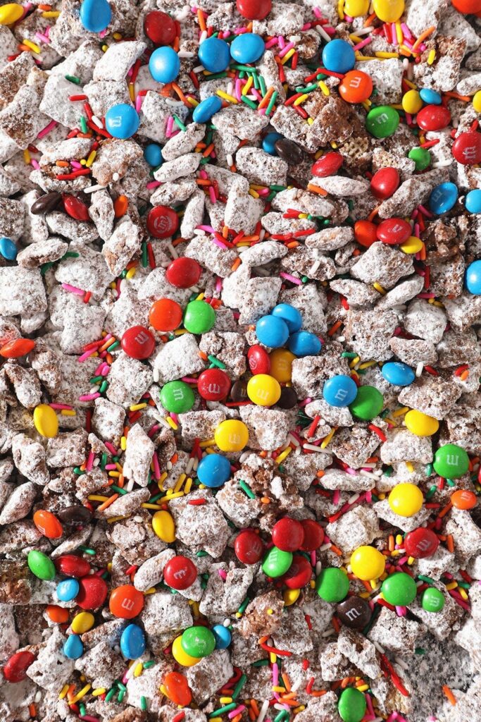 Close up of chocolate candies and sprinkles on top of a sweet snack mix